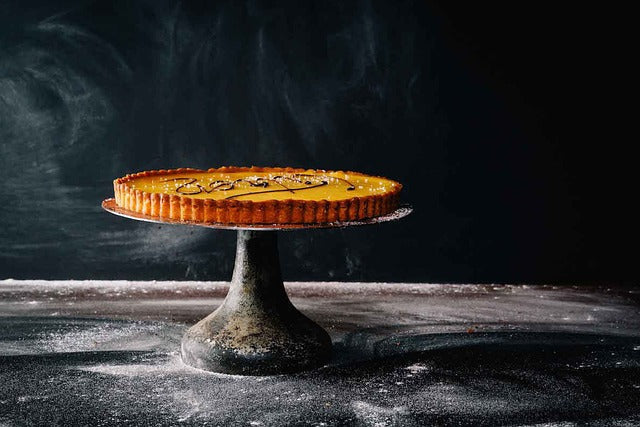 Eine Tarte auf einem Kuchenständer.