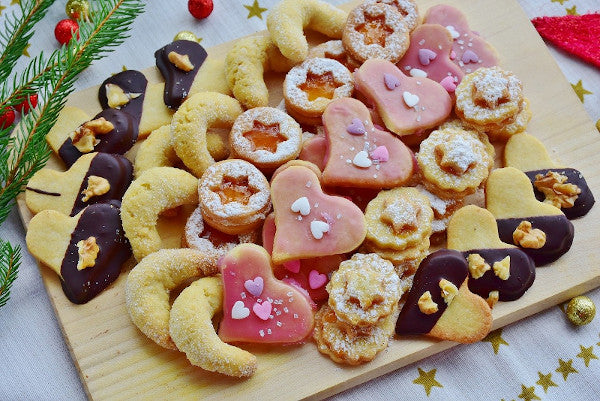 Auf einem Holzbrett sind einige verschiedene Plätzchen serviert