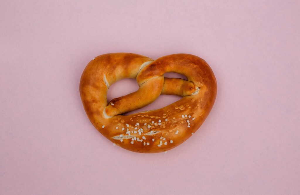 Auf einem rosa Untergrund liegt eine Brezel