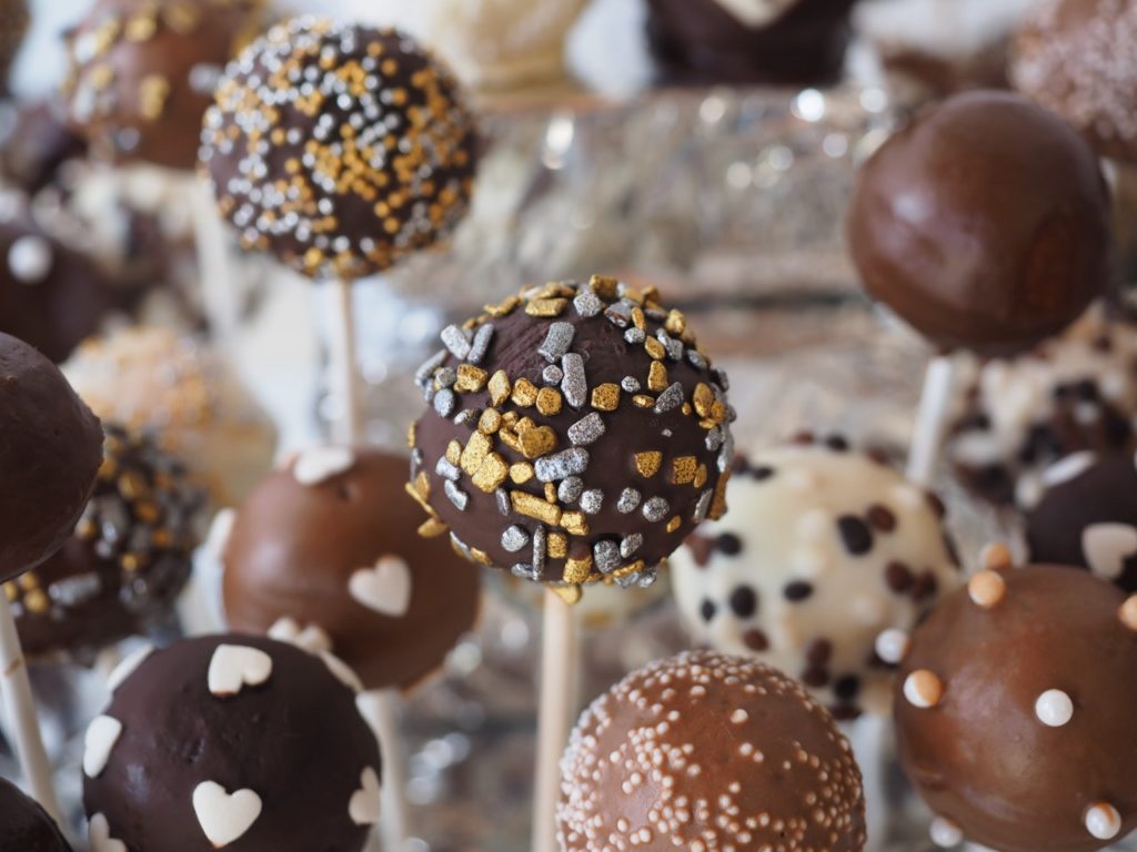Man sieht einige Cake Pops, welche mit verschiedenen Schokoladenarten und Streuseln verziert wurden
