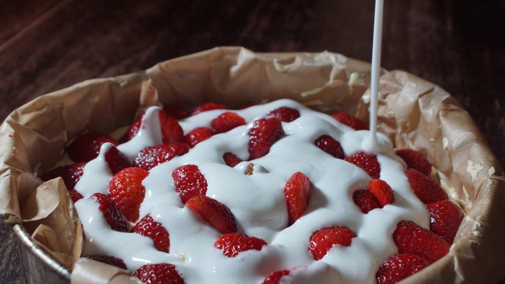 Eine Schüssel Erdbeeren wird von Zuckerguss übergossen