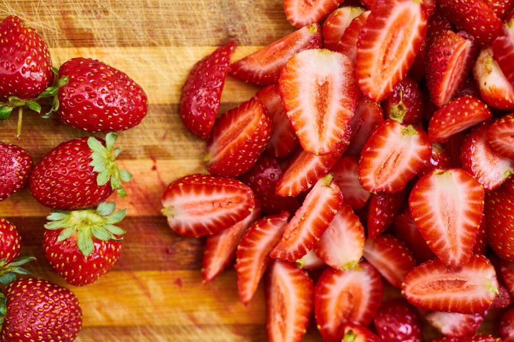 Einige Gartenerdbeeren liegen auf einem Holz-Schneidebrett
