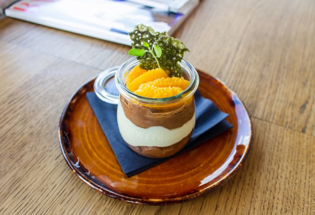 Ein Kuchen im Glas wurde mit Mandarinen und etwas Grün garniert