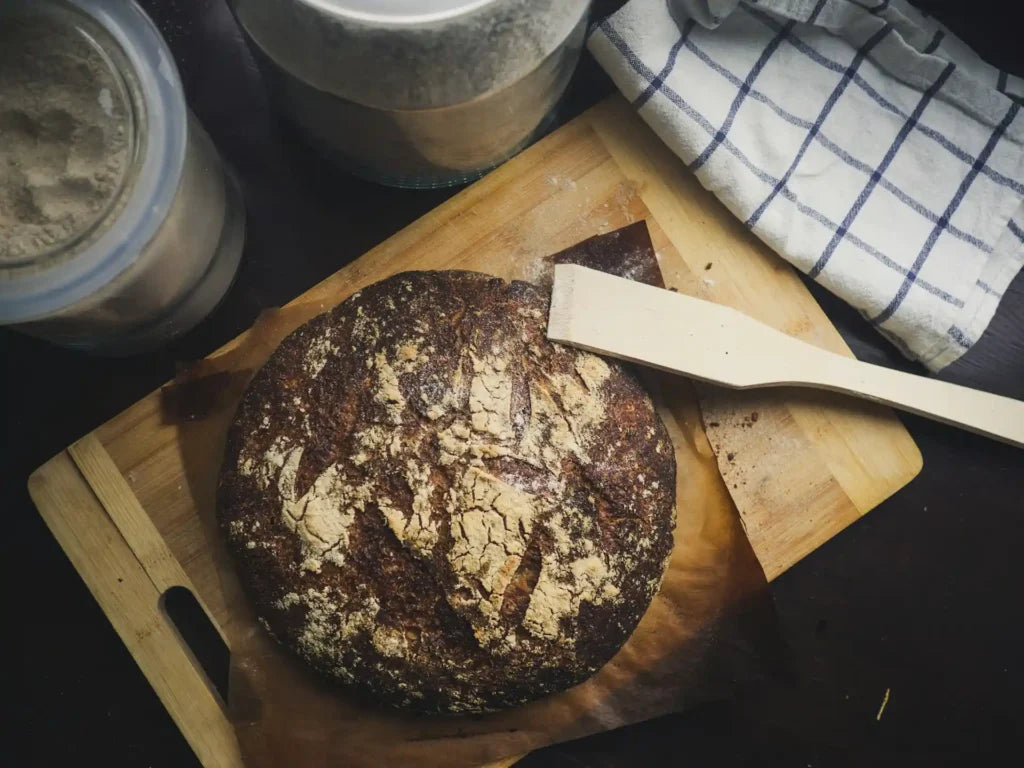Frisch gebackener Roggenbrotteig auf einem braunen Holzbrett