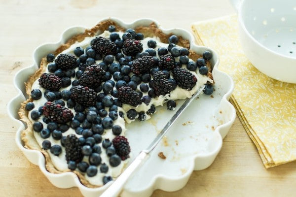 Eine angeschnittene Torte mit Blau- und Brombeeren.