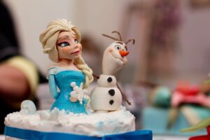 Fondantfiguren aus dem Film Frozen stehen auf einer Torte