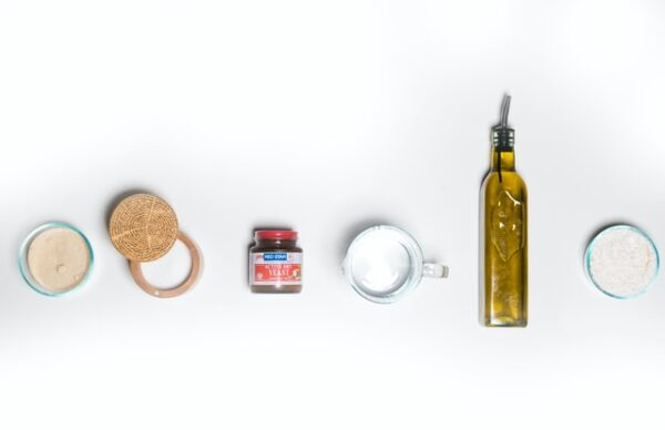 Salz, Hefe, Wasser, Öl und Mehl vor einem weißen Hintergrundx