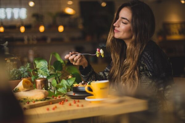 Eine Frau sitzt an einem Tisch und genießt ihr Essen