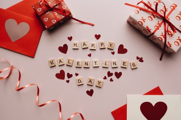 Schriftzug Happy Valentines Day mit Herzen und Geschenken