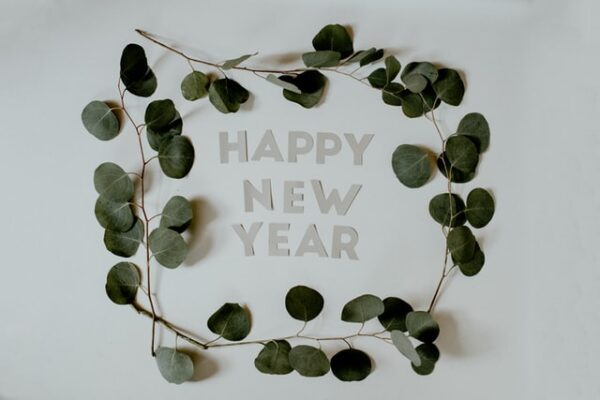 Die Wort Happy New Year ausgeschnitten und drumherum ein Kranz aus Eukalyptusblättern