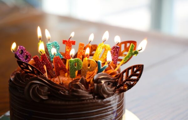 Ein Kuchen mit brennenden Happy-Birthday-Kerzen