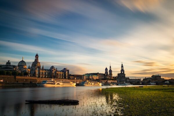Eine Panoramaaufnahme der Altstadt Dresden vom anderen Elbufer aus vor abendlichem Himmel